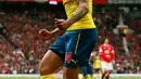 Gelandang Arsenal, Theo Walcott melakukan selebrasi usai pemain MU, Tyler Blackett melakukan gol bunuh diri di Laga Liga Premier Inggris di Old Trafford, Minggu (17/5/2015). Manchester United bermain imbang 1-1 atas Arsenal. (Reuters/Jason Cairnduff)