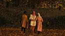 Para wanita berjalan melewati pepohonan yang merontokkan daun musim gugur mereka di taman Nishat Bagh di Srinagar (16/11/2020). (AFP/Tauseef Mustafa)