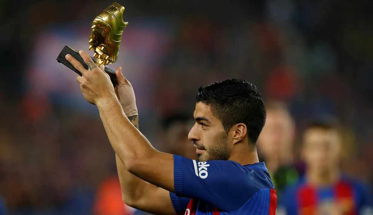 Striker Barcelona, Luis Suarez, menunjukan Sepatu Emas jelang laga La Liga melawan Granada di Stadion Nou Camp, Spanyol, Sabtu (29/10/2016). Suarez meraih gelar ini usai mencetak 40 gol pada musim lalu. (Reuters/Albert Gea)