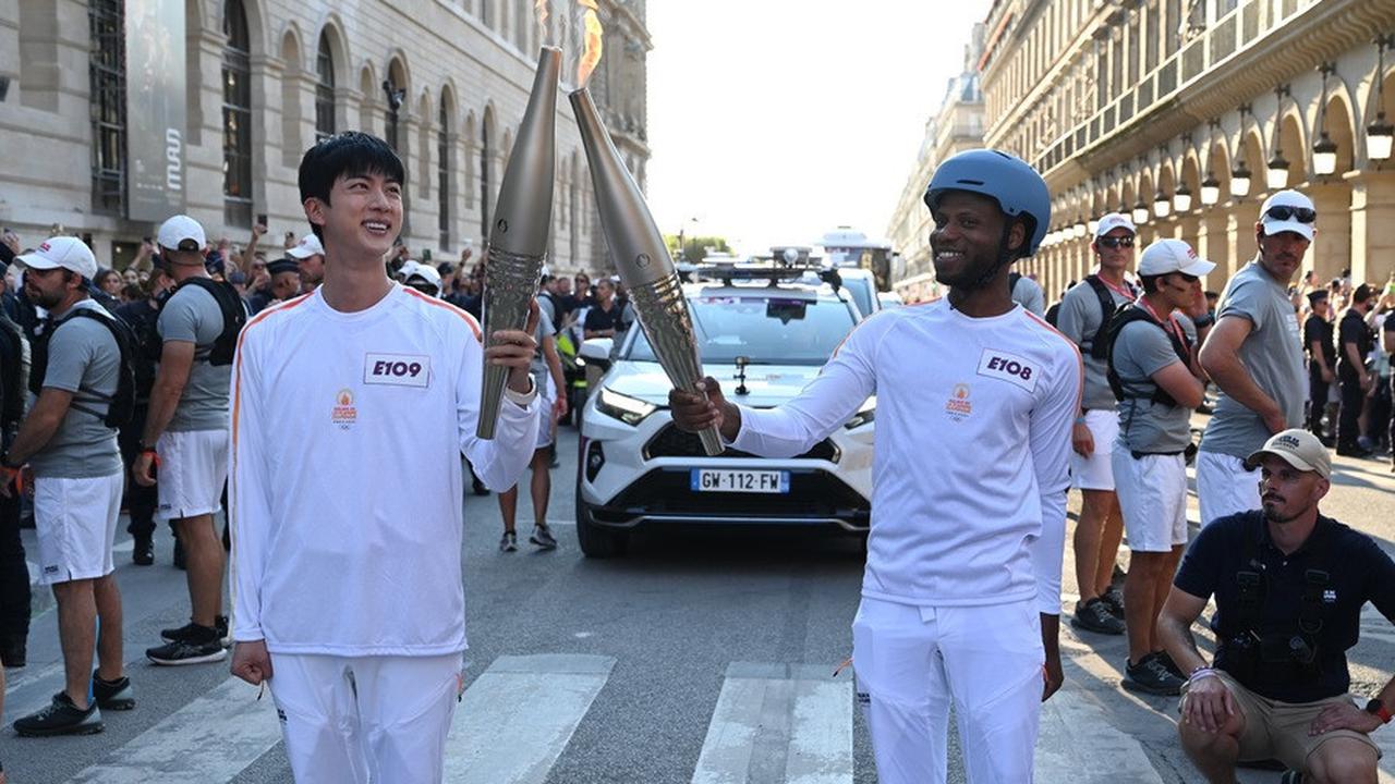 Seperti pembawa obor lainnya, Jin juga mengenakan jersey serba putih khas Olimpiade Paris.