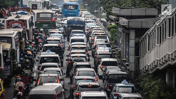 Kendaraan roda dua dan empat tampak terjebak macet panjang di kawasan Jalan Gatot Subroto, Jakarta, Minggu (9/12). Para suporter Persija ingin menyaksikan pertandingan bola klub Persija melawan Mitra Kukar. (Liputan6.com/Faizal Fanani)