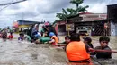 Para relawan membantu warga melewati derasnya banjir di Makassar pada 12 Februari 2025. (DAENG MANSUR/AFP)