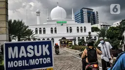 Petugas membagikan takjil kepada pengendara secara drive thru di Kompleks Masjid Al-Azhar, Jakarta, Selasa (13/4/2021). Pengelola Masjid Al-Azhar menyiapkan 500 bungkus takjil per hari yang dibagikan secara drive thru guna mencegah penyebaran COVID-19. (merdeka.com/Iqbal S. Nugroho)