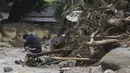 Seorang pria bereaksi di samping rumahnya yang runtuh setelah tanah longsor yang disebabkan oleh hujan lebat di Yecheon, Korea Selatan, Minggu, 16 Juli 2023.(Yun Kwan-shick/Yonhap via AP)
