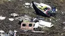 Seorang tim regu penyelamat duduk diantara puing-puing pesawat  LaMia Airlines yang terjatuh di areal hutan Kolombia, (29/11/2016).  (Reuters/Jaime Saldarriaga)