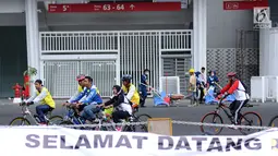 Warga bersepeda melintasi kawasan lingkar luar Stadion Gelora Bung Karno (GBK), Jakarta, Minggu (21/1). Pascarenovasi, kawasan sekitar Stadion GBK kembali dipadati warga yang berolahraga. (Liputan6.com/Helmi Fithransyah)