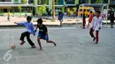 Dua anak berebut bola saat bermain futsal di lapangan Rusun Muara Kapuk, Jakarta, Jumat (22/4/2016). Rusun Muara Kapuk sediakan fasilitas lapangan sebagai sarana bermain untuk anak-anak. (Liputan6.com/Yoppy Renato)