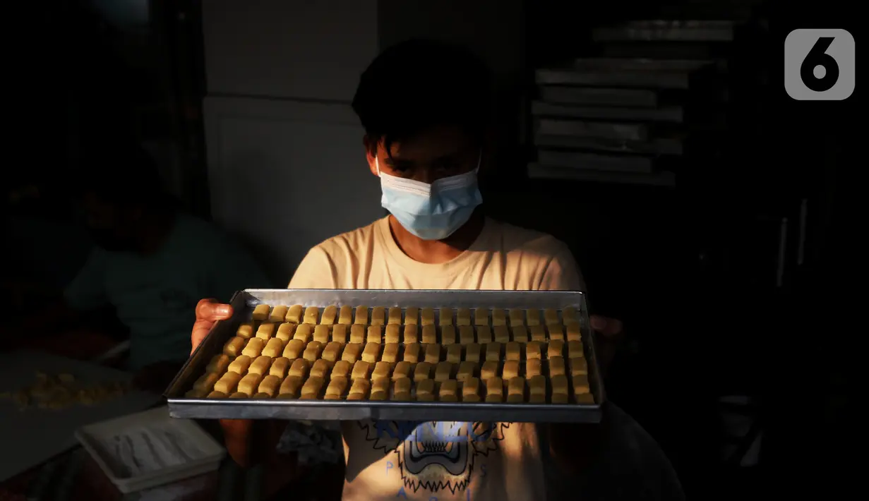 Pekerja menunjukkan kue kering di industri rumahan Dea cake di Tangerang, Selasa (27/4/2021). Kue kering tersebut di jual dari 100 ribu  hingga 300 ribu sesuai ukuran toples. (Liputan6.com/Angga Yuniar)