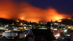 Langit memerah akibat kebakaran yang melanda kawasan Dichato Chili, Senin (30/1). Ketika kebakaran melanda kota Santa Olga pada Kamis malam, menewaskan 10 orang dan menghanguskan lebih dari 1.000 bangunan. (AP Photo / Esteban Felix)