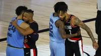Ekspresi pemain Portland Trail Blazers dan Memphis Grizzlies berpelukan selepas laga play-in NBA di The Field House, Florida, Minggu (16/8/2020) pagi WIB. (Kevin C. Cox/Getty Images via AFP)