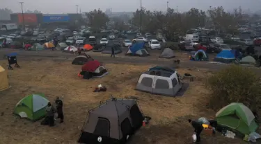 Sejumlah tenda terpasang di kamp pengungsian di sebuah lapangan di samping tempat parkir Walmart, Chico, California, AS (16/11). Akibat kebakaran yang terjadi di California sekitar 63 orang tewas. (AFP Photo/Justin Sullivan)