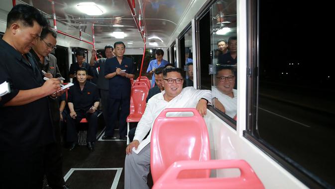 Pemimpin Korea Utara Kim Jong-Un duduk di dalam bus saat menjajal bus jenis baru yang diproduksi selama kunjungan ke pabrik bus di Pyongyang, (4/8). Dalam kunjungannya Kim Jong-un juga menyempatkan diri untuk melakukan 'test-drive'. (AFP Photo/KCNA)
