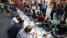 Sejumlah orang mempersiapkan diri untuk berbuka puasa pada hari pertama bulan suci Ramadan, di dekat Taksim Square, Istanbul, Turki, Kamis (18/6/2015). (REUTERS/Osman Orsal)
