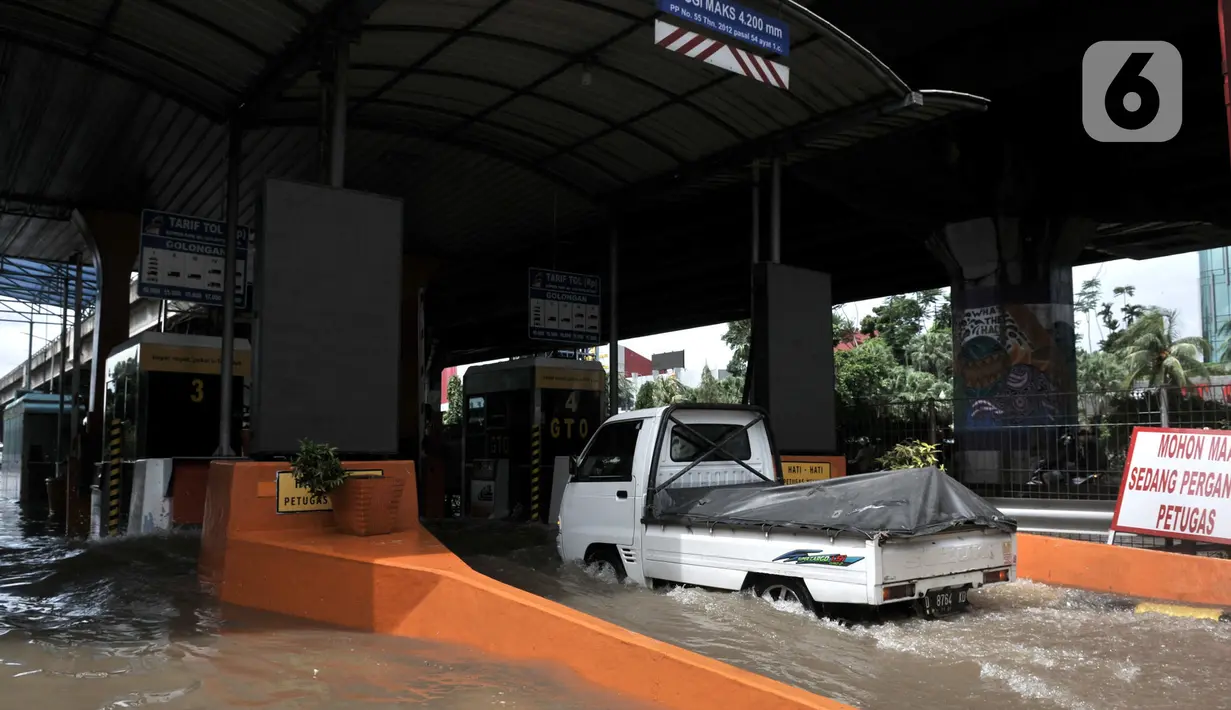 Mobil nekat menerobos banjir menuju Gerbang Tol Cempaka Putih, Jakarta, Minggu (23/2/2020). Banjir yang melanda kawasan tersebut menyebabkan Gerbang Tol Cempaka Putih tidak dioperasikan akibat terendam hingga ketinggian mencapai sepinggang orang dewasa. (merdeka.com/Iqbal S. Nugroho)