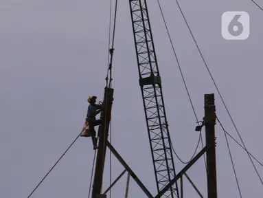 Pekerja tengah melakukan aktivitas kerja pada ketinggian di menara sutet di kawasan Karang Tengah, Kota Tangerang, Banten, Jumat (8/1/2021). Keselamatan dan kesehatan kerja (K3) merupakan hal yang mutlak bagi para pekerja di ketinggian dengan risiko tinggi. (Liputan6.com/Angga Yuniar)