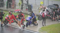 Pembalap dan kru berjalan menuju paddock saat hujan lebat sebelum Race 2 WSBK Mandalika 2021 di Pertamina Mandalika International Street Circuit, Lombok, Nusa Tenggara Barat, Minggu (21/11/2021). Balapan dilanjutkan pukul 15.30 WIB atau 16.30 Wita dan hanya digelar 12 lap. (BAY ISMOYO/AFP)