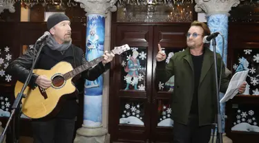 The Edge dan Bono U2 saat mengambil bagian dalam acara Malam Natal di Grafton Street, Dublin (24/12). (AP Photo/Lorraine O'Sullivan)