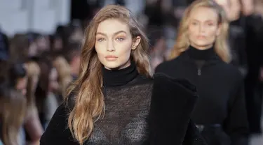 Supermodel Gigi Hadid berjalan di atas catwalk mengenakan busana karya Max Mara selama Autumn / Winter 2017 di Milan Fashion Week, Italia (23/2). Gigi Hadid tampil cantik dan seksi dengan busana tipis berwarna hitam. (AP Photo / Luca Bruno)