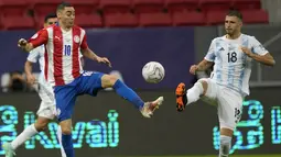 Gelandang Paraguay, Miguel Almiron berebut bola dengan gelandang Argentina, Guido Rodriguez pada pertandingan partai matchday 3 Grup A Copa America 2021 di Stadion Nasional, Brasil, Selasa (22/6/2021). Argentina menang tipis atas Paraguay 1-0 berkat gol tunggal Gomez. (AP Photo/Ricardo Mazalan)