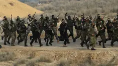 Militan Palestina dengan wajah dicat berbaris dengan senjata mereka dan meneriakkan slogan-slogan selama latihan militer yang diselenggarakan oleh faksi-faksi militer di Rafah, Jalur Gaza selatan, Rabu (29/12/2021). (AP Photo/Adel Hana)