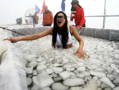 Sebuah acara berendam di kolam es digelar di Zhangjiajie, Tiongkok. Gambar ini diambil pada 25 Januari 2015. (AFP Photo)