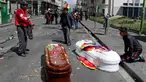 Peti mati berisi jenazah orang yang tewas dalam bentrokan antara pasukan keamanan dengan pendukung mantan Presiden Evo Morales tergeletak di tengah jalan setelah polisi meluncurkan gas air mata pada prosesi pemakaman besar-besaran di El Paz, Bolivia, Kamis (21/11/2019). (AP Photo/Juan Karita)