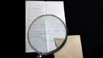 Petugas rumah lelang Winner melihat surat yang ditulis tangan Albert Einstein mengenai rumusan "Tahap Ketiga Teori Relativitas" dengan kaca pembesar di Yerusalem, Selasa (6/3). Surat itu dibeli dengan harga sekitar Rp 1,2 miliar. (MENAHEM KAHANA/AFP)