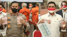 Karopenmas Divisi Humas Polri Bridgjen Rusdi Hartono (kiri) menunjukkan barang bukti uang palsu saat rilis di Gedung Lobby Bareskrime Mabes Polri, Jakarta, Kamis (23/9/2021). Bareskrim Polri mengungkap kasus tindak pidana pemalsuan uang dan peredaran uang palsu. (Liputan6.com/Faizal Fanani)