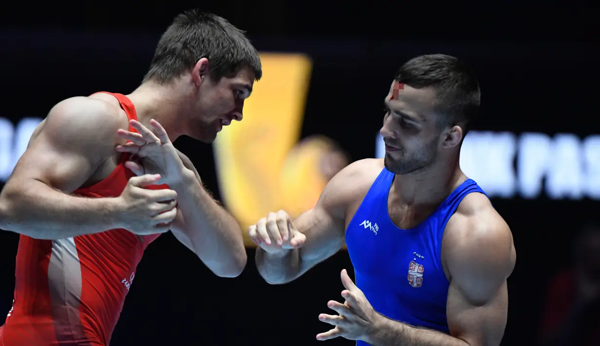 Pegulat Rusia, Aleksandr Chekhirkin mengalami cedera di dahi saat bertanding melawan Victor Nemes (Serbia) pada Kejuaraan Gulat Dunia di Paris, Prancis, Senin (21/8). Aleksandr tetap melanjutkan pertandingan dengan kepala yang diperban (BERTRAND GUAY/AFP)