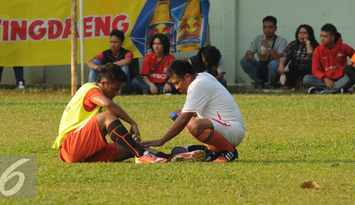 Pesepakbola Persija, Gunawan DwiCahyo (kiri) mendapat perawatan medis akibat jatuh saat latihan di Markas Yon Zikon 14, Jakarta, Senin (24/8/2015). Persija kembali berlatih untuk menghadapi turnamen Piala Presiden 2015. (Liputan6.com/Helmi Fithriansyah)