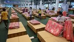 Pekerja menyiapkan kasur dan selimut untuk tempat tidur kardus di rumah sakit lapangan Covid-19 di dalam gudang Bandara Internasional Don Mueang di Bangkok, Selasa (27/7/2021). Thailand menghadapi rekor jumlah kasus virus corona di tengah kampanye vaksinasi yang lambat. (Lillian SUWANRUMPHA/AFP)
