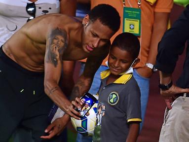 Pemain Brasil, Neymar Junior berfoto selfie bersama seorang anak kecil pada sesi latihan di Salvador, Brasil, Senin(16/11/2015). Brasil akan melawan Peru pada Qualifikasi Piala Dunia Rusia 2018. AFP Photo/Christophe Simon)