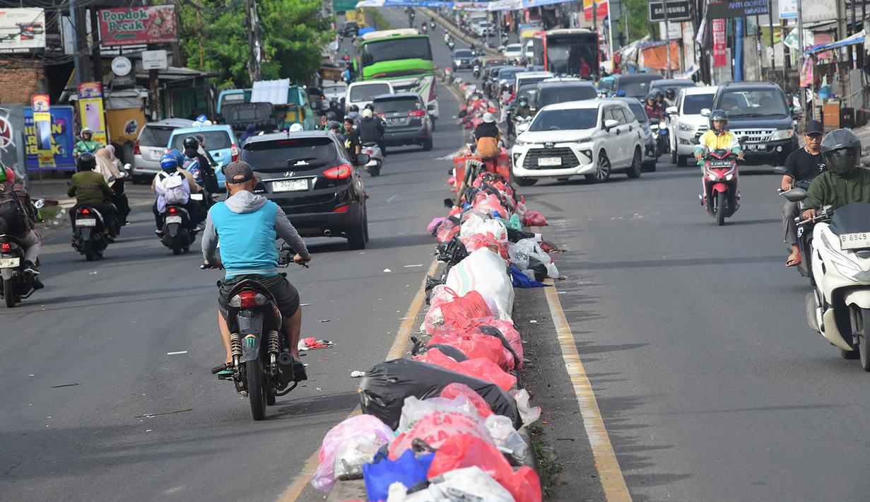 Warga mengeluhkan dengan keberadaan tumpukan sampah di beberapa ruas jalan yang tak kunjung diangkut. Tampak dalam foto, tumpukan sampah diletakkan pada pembatas salah satu ruas jalan di kawasan Pasar Manggis, Ciputat, Tangerang Selatan, Senin (15/12/2025). (merdeka.com/Arie Basuki)