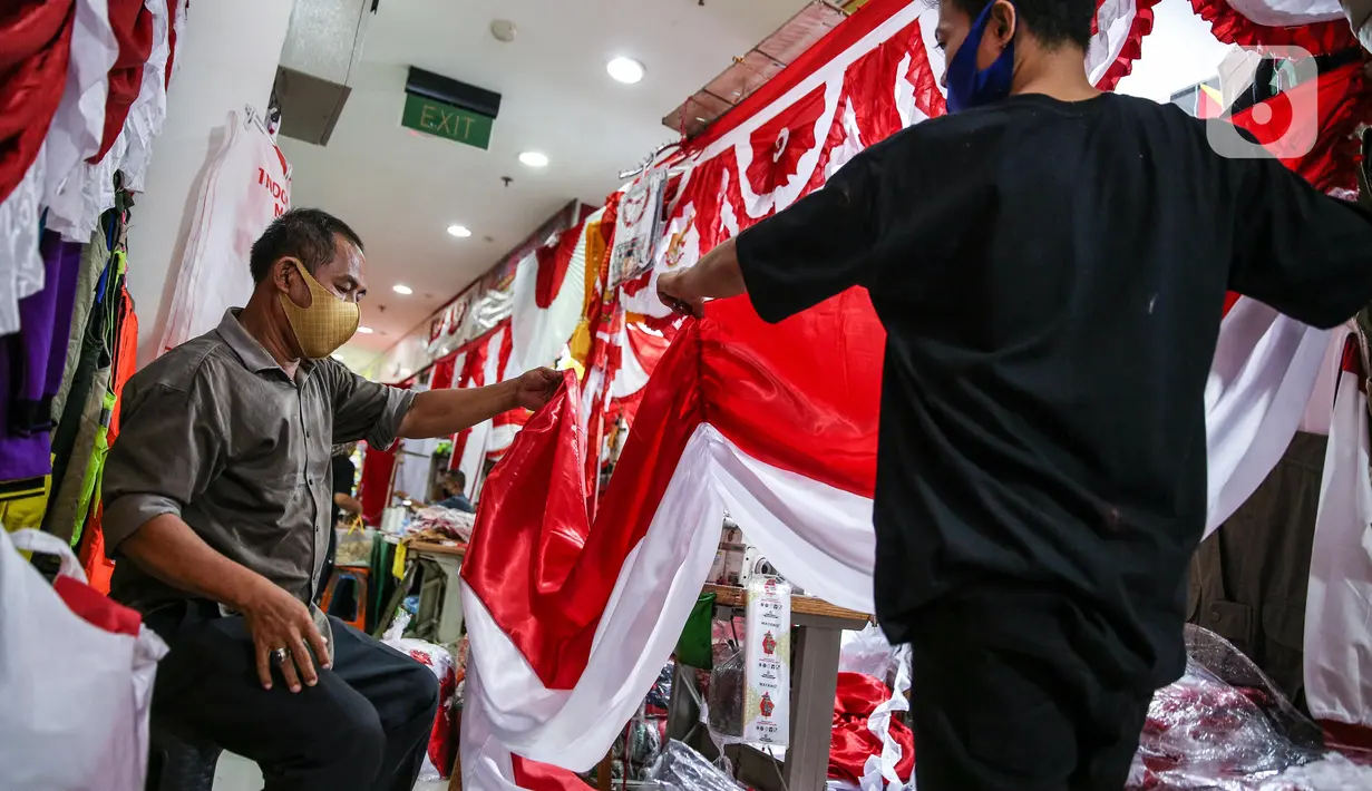 Aktivitas penjahit bendera merah putih di kiosnya, kawasan Pasar Senen, Jakarta, Rabu (5/8/2020). Menjelang peringatan HUT ke-75 Kemerdekaan RI, sejumlah pedagang mengaku penjualan pernak-pernik bendera merah putih menurun 50 persen dibanding tahun lalu akibat COVID-19. (Liputan6.com/Faizal Fanani)