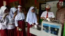 Para siswa antre mengambil air bersih langsung dari keran di SDN 03 dan SDN 04 Penjaringan, Jakarta, Jumat (22/3). Kegiatan ini bertujuan menyediakan air siap minum yang higenis dan bersih bagi siswa serta guru. (merdeka.com/Imam Buhori)