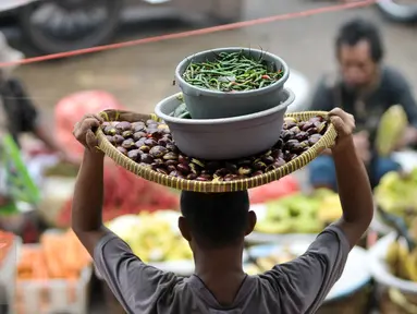  Pedagang membawa cabai di pasar tradisional, Jakarta, Senin (10/10). Kenaikan harga cabai keriting terimbas kondisi cuaca yang kurang baik sehingga membuat pasokan berkurang. (Liputan6.com/Yoppy Renato)