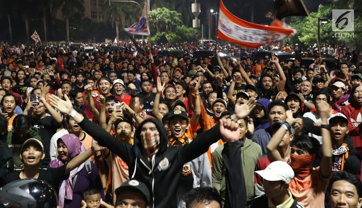 Suporter tim Macan Kemayoran merayakan gelar juara Go-Jek Liga 1 Indonesia 2018 bersama Bukalapak yang diraih Persija di kawasan Bundaran HI, Jakarta, Minggu (9/12). Persija meraih gelar juara dengan 62 poin. (Liputan6.com/Helmi Fithriansyah)