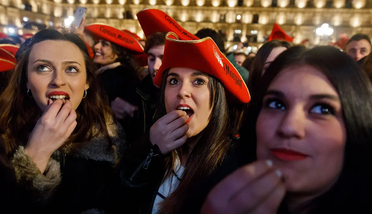 Masyarakat Spanyol makan dua belas butir anggur saat bel dibunyikan di malam tahun baru. Ritual ini akan membawa kemakmuran di tahun mendatang menurut mitos yang mereka percayai.( AFP PHOTO / Cesar Manso)