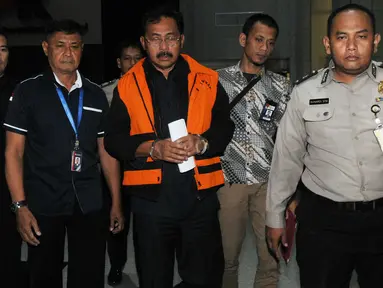 Gubernur Kepulauan Riau (Kepri) Nurdin Basirun dikawal petugas usai menjalani pemeriksaan 1 x 24 jam di Gedung KPK, Jakarta, Jumat dini hari (12/7/2019). Nurdin Basirun resmi ditahan KPK bersama tiga tersangka terkait suap izin lokasi rencana reklamasi di wilayah Kepri. (merdeka.com/Dwi Narwoko)
