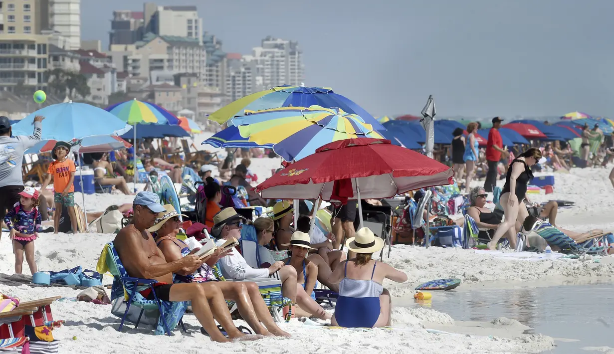 Para pengunjung berkumpul menikmati pantai di Destin, Florida, Amerika Serikat, Rabu (18/3/2020). Pantai Florida masih ramai dikunjungi pengunjung kendati virus corona COVID-19 telah menyebar ke seluruh Amerika Serikat. (Devon Ravine/Northwest Florida Daily News via AP)