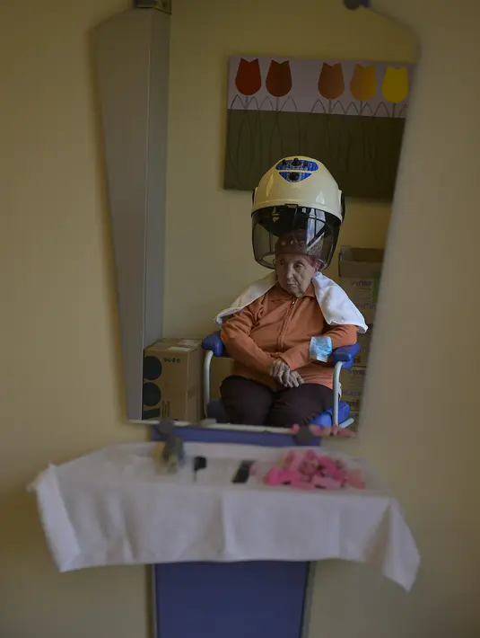 Maribel Elizondo, 90 tahun, duduk di salon rambut di panti jompo Ibaneta, di desa kecil Erro, sekitar 30 km (18 mil) dari Pamplona, Spanyol utara, Senin, 22 Maret 2021. Setiap minggu, pada hari Senin, penata rambut Gloria Cerdan melayani para penghuni di panti jompo. (AP Photo/Alvaro Barrientos)