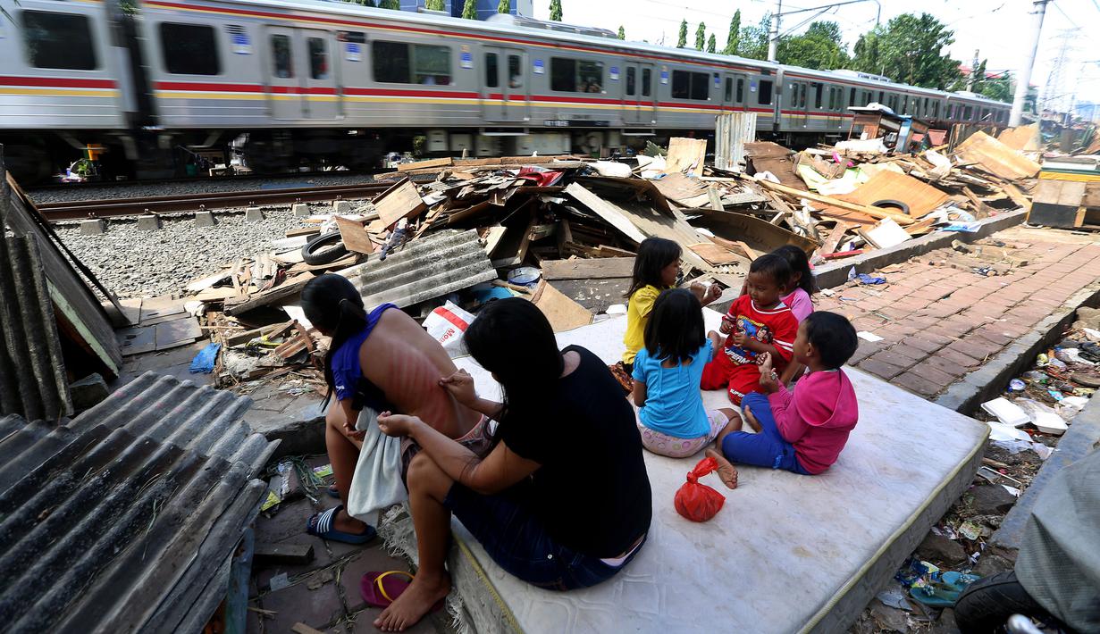 Warga beraktivitas didekat puing bongkaran rumah di area Rusun Bendungan Hilir (Benhil) II, Jakarta, Minggu (3/12). (Liputan6.com/JohanTallo)