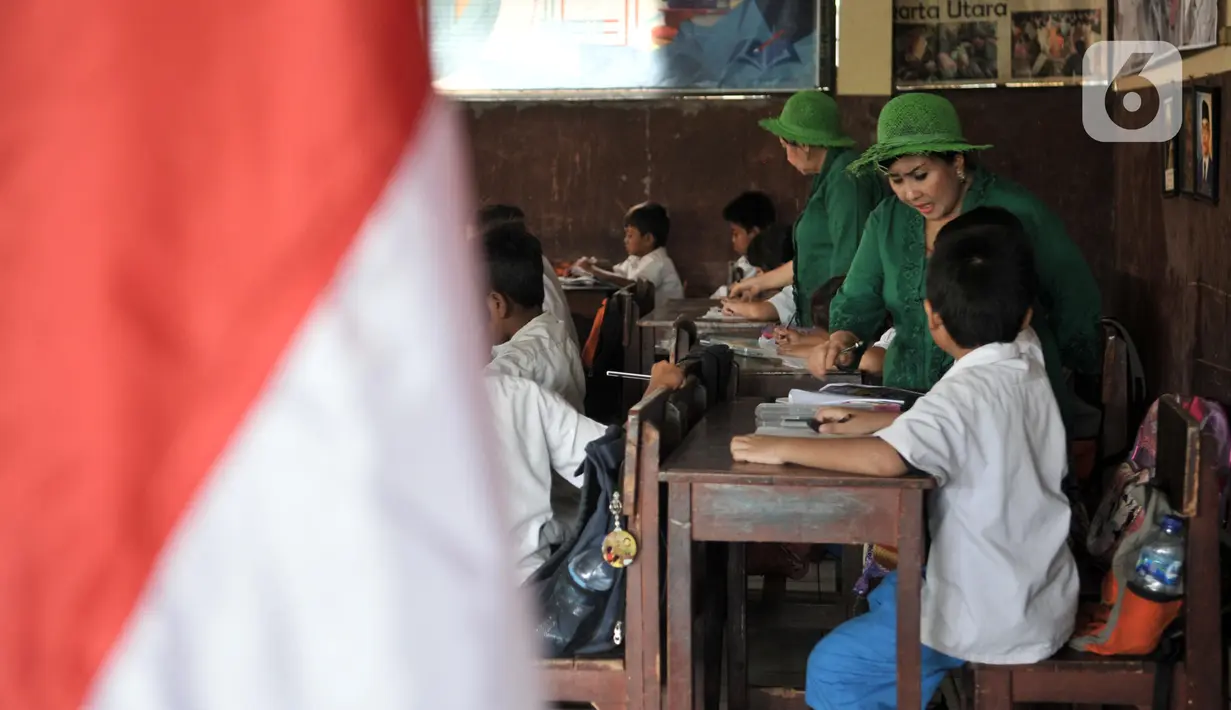 Sri Irianingsih (depan) dan Sri Rossyati (belakang) saat mengajar di Sekolah Darurat Kartini, Lodan, Jakarta Utara, Senin (25/11/2019). Kini, tercatat ada 300 peserta didik mengikuti kegiatan di sekolah sejak pukul 07.00 hingga 12.00 WIB setiap Senin sampai Jumat. (merdeka.com/Iqbal Nugroho)