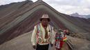 Seorang pria Andes berpose bersama llamanya di Gunung Pelangi di Pitumarca, Peru (2/4). Makin banyaknya wisatawan untuk melihat keindahan gunung tersebut menjadi ladang pekerjaan baru bagi warga sekitar. (AP Photo/Martin Mejia)