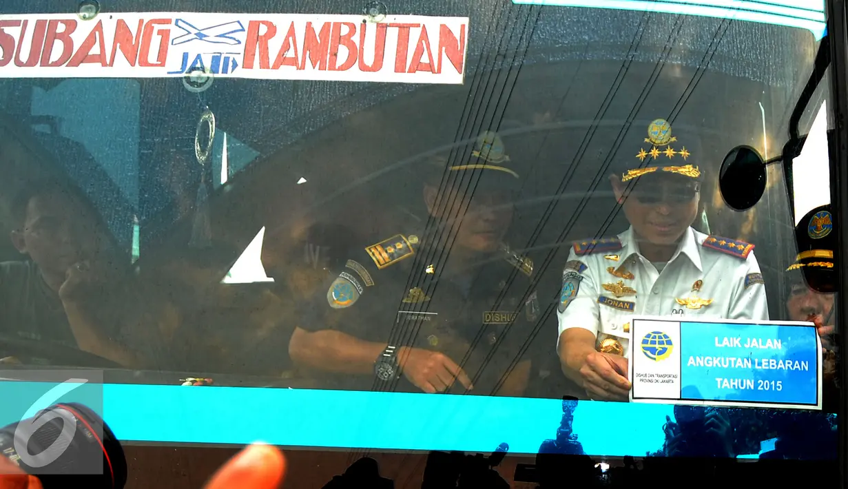 Menteri Perhubungan Ignasius Jonan memasang stiker tanda laik jalan  di Terminal Kp.Rambutan, Jakarta, Jumat (10/7/2015).  Kedatangan Jonan untuk memastikan kesiapan layanan angkutan mudik Lebaran 2015. (Liputan/Yoppy Renato)