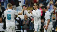 Striker Real Madrid, Gareth Bale, melakukan selebrasi bersama Toni Kroos usai mencetak gol ke gawang Celta Vigo pada laga La Liga di Stadion Santiago Bernabeu, Sabtu (12/5/2018). Real Madrid menang 6-0 atas Celta Vigo. (AP/Paul White)