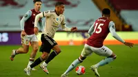 Striker Manchester United, Mason Greenwood, berebut bola dengan bek Aston Villa, Ezri Konsa, pada laga lanjutan Premier League di Villa Park, Jumat (10/7/2020) dini hari WIB. Manchester United menang 3-0 atas Aston Villa. (AFP/Andrew Boyers/pool)
