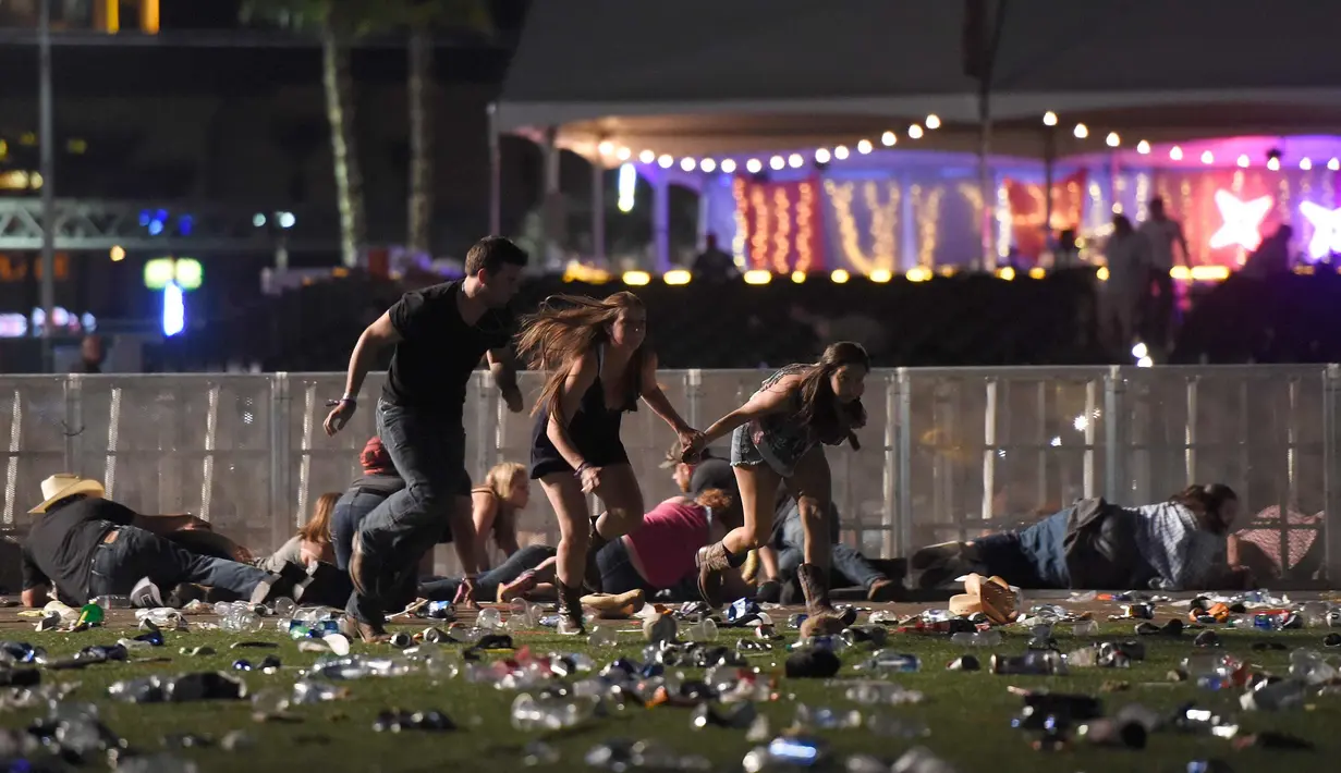 Sejumlah pengunjung berlari dari festival musik Route 91 Harvest country setelah aksi penembakan di Las Vegas, Nevada (1/10). Penembakan dilaporkan terjadi di areal Kasino Mandalay Bay, Las Vegas, Amerika Serikat. (David Becker/Getty Images/AFP)