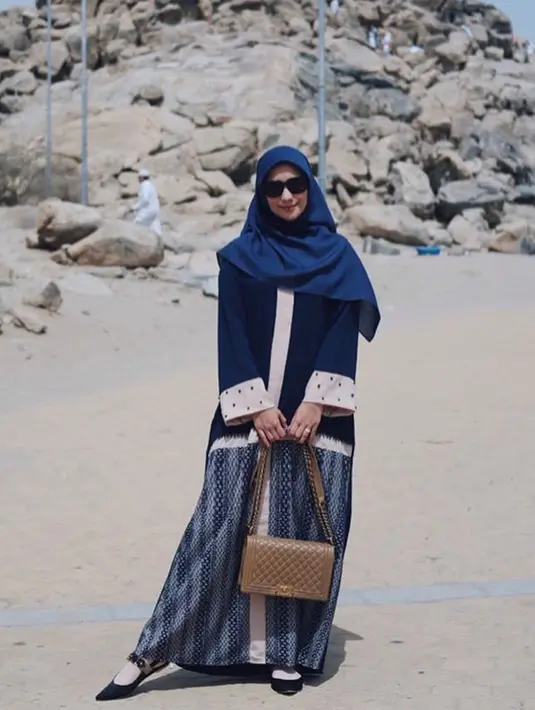 Saat mengunjungi Jabal Rahmah di Mekkah, Citra tampak menawan dengan gamis bercorak yang berwarna biru dan putih dipadupadankan dengan hijab dan kacamata yang menambah aura kecantikannya. (Liputan6.com/IG/@citraciki)