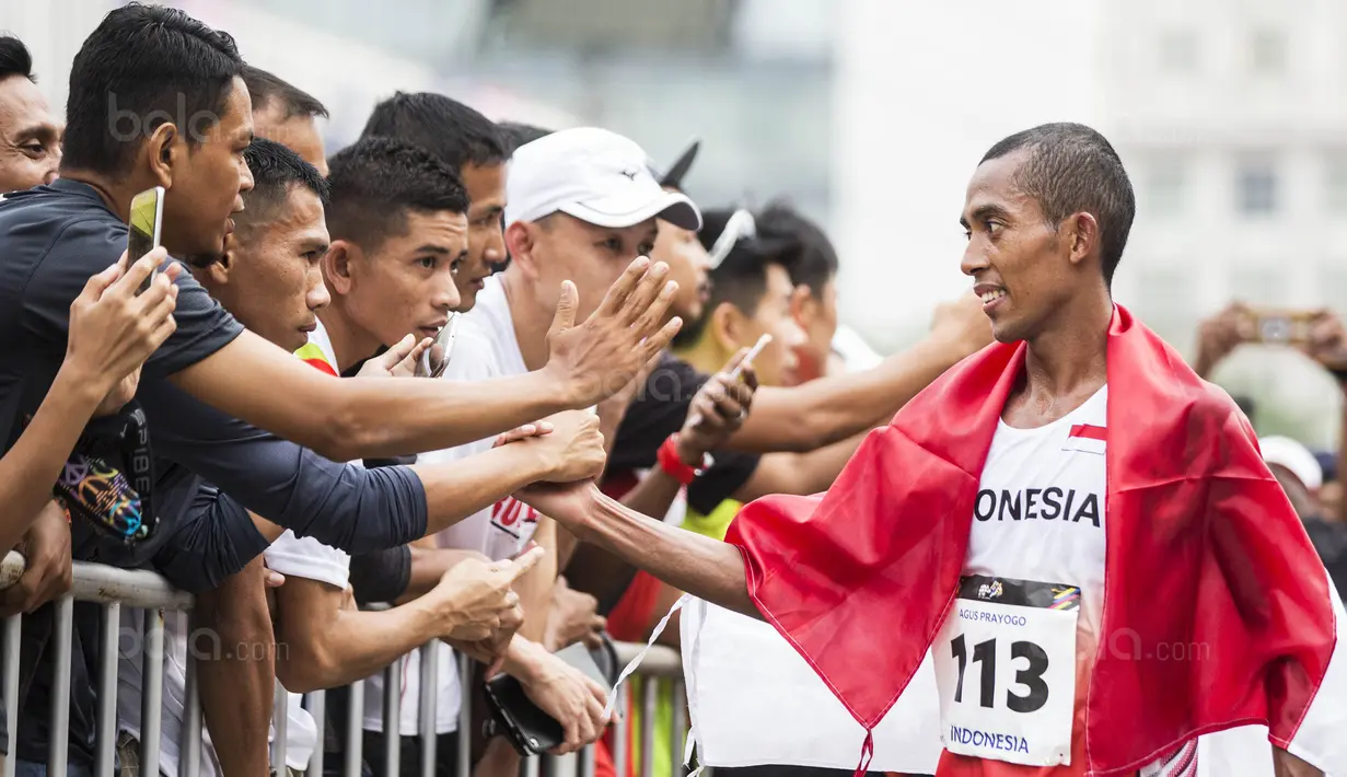 Pelari Indonesia, Agus Prayogo, menyapa suporter usai tampil pada nomor marathon SEA Games di Putrajaya, Kuala Lumpur, Sabtu (19/8/2017). Agus meraih medali perak dengan waktu dua jam 27 menit 16 detik. (Bola.com/Vitalis Yogi Trisna)